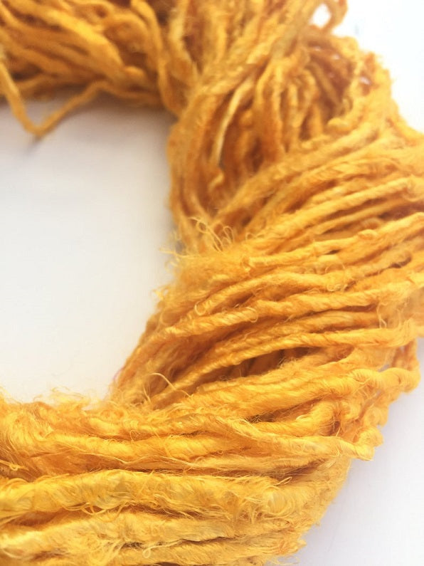 Banana yarn in Golden Yellow, skein on white background - silk-routeindia