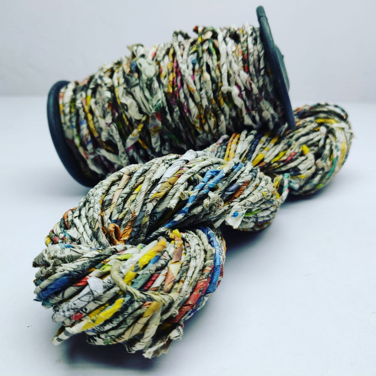 Handspun newspaper yarn, ball on white background - silk-routeindia