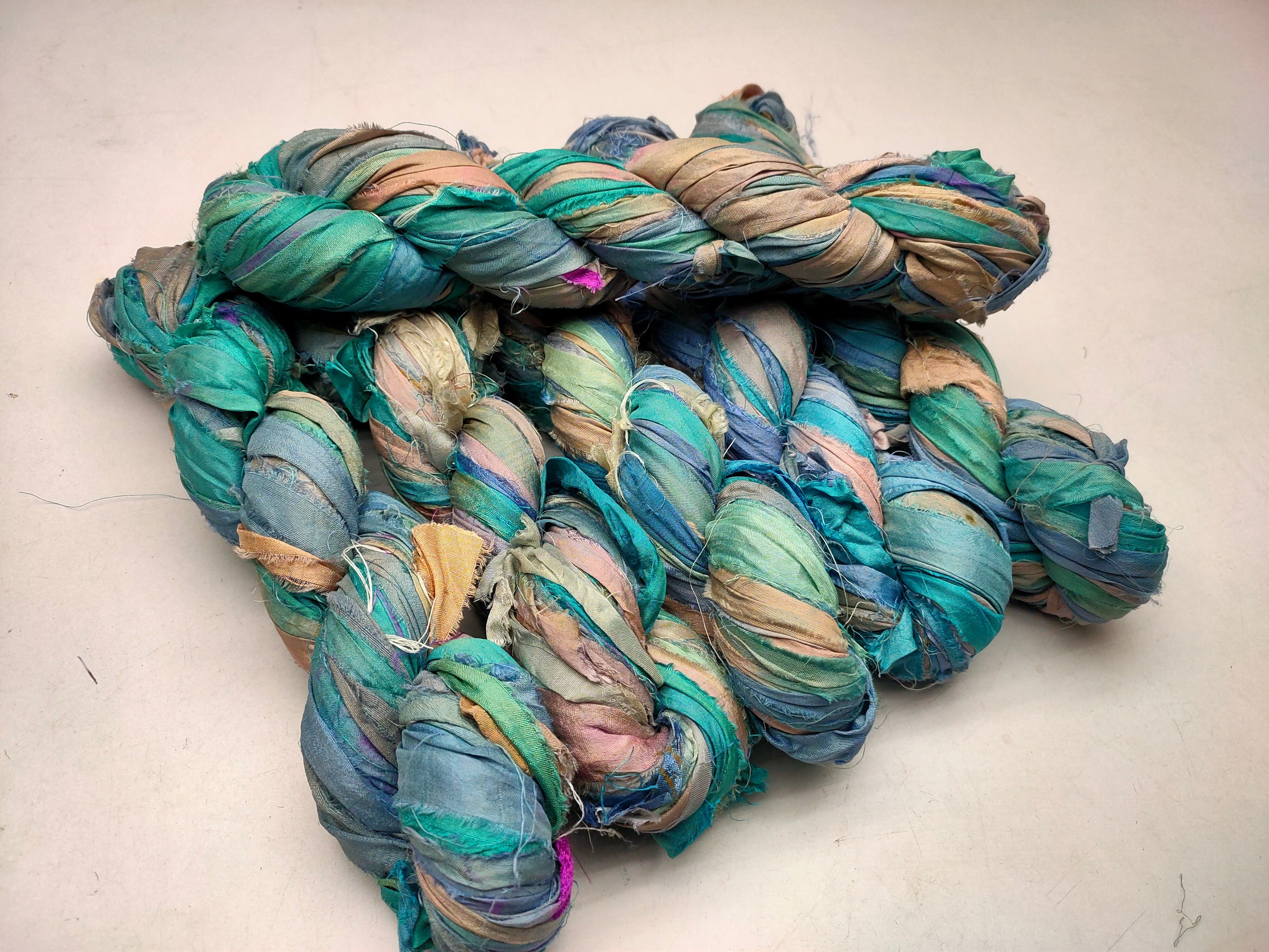 Recycled Sari silk Ribbon is the by-product of colorful saris that women wear in India. It is the loose ends of saris collected from industrial mills in India that is torn in stripes and sewn end to end to make beautiful and colorful ribbons. 