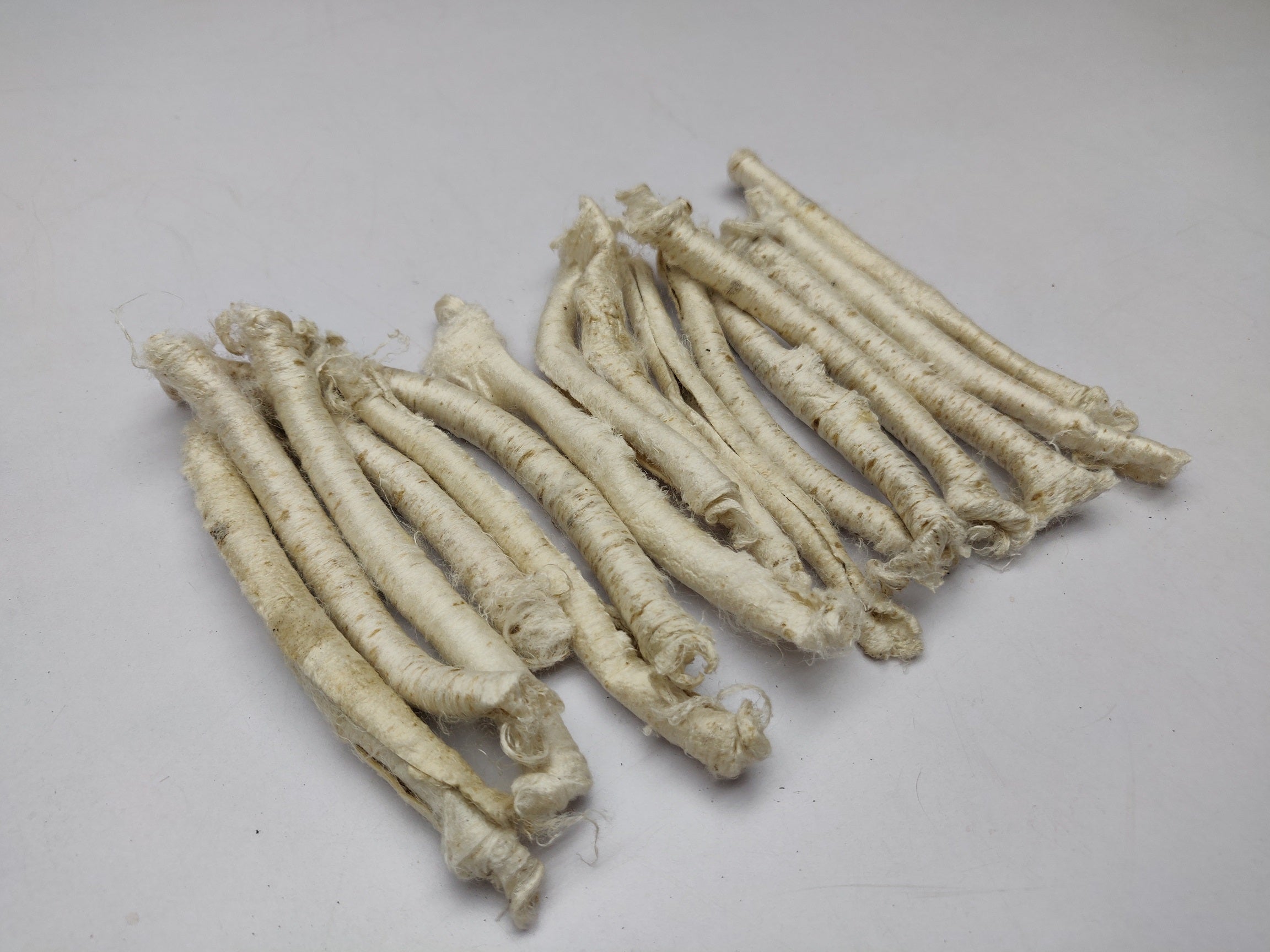 Mulberry Silk Carrier Rods - SilkRouteIndia - Carrier Rods are a waste product in the silk spinning industry. Perfect for surface texture during felting and can be dyed as per need. If you sprinkle it with water and iron them flat then you can create a sort of silk paper. Original pieces will be criss cross or slightly twisted. Use them in your felting, create unique and interesting jewelry, textural stitching and silk fusion. 